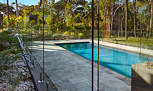 Frameless Glass pool fence surrounding a backyard pool