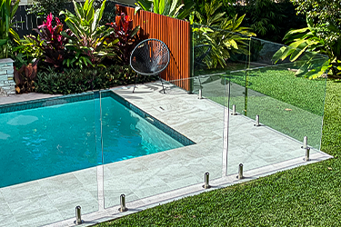 Frameless Glass fence surrounding a backyard pool